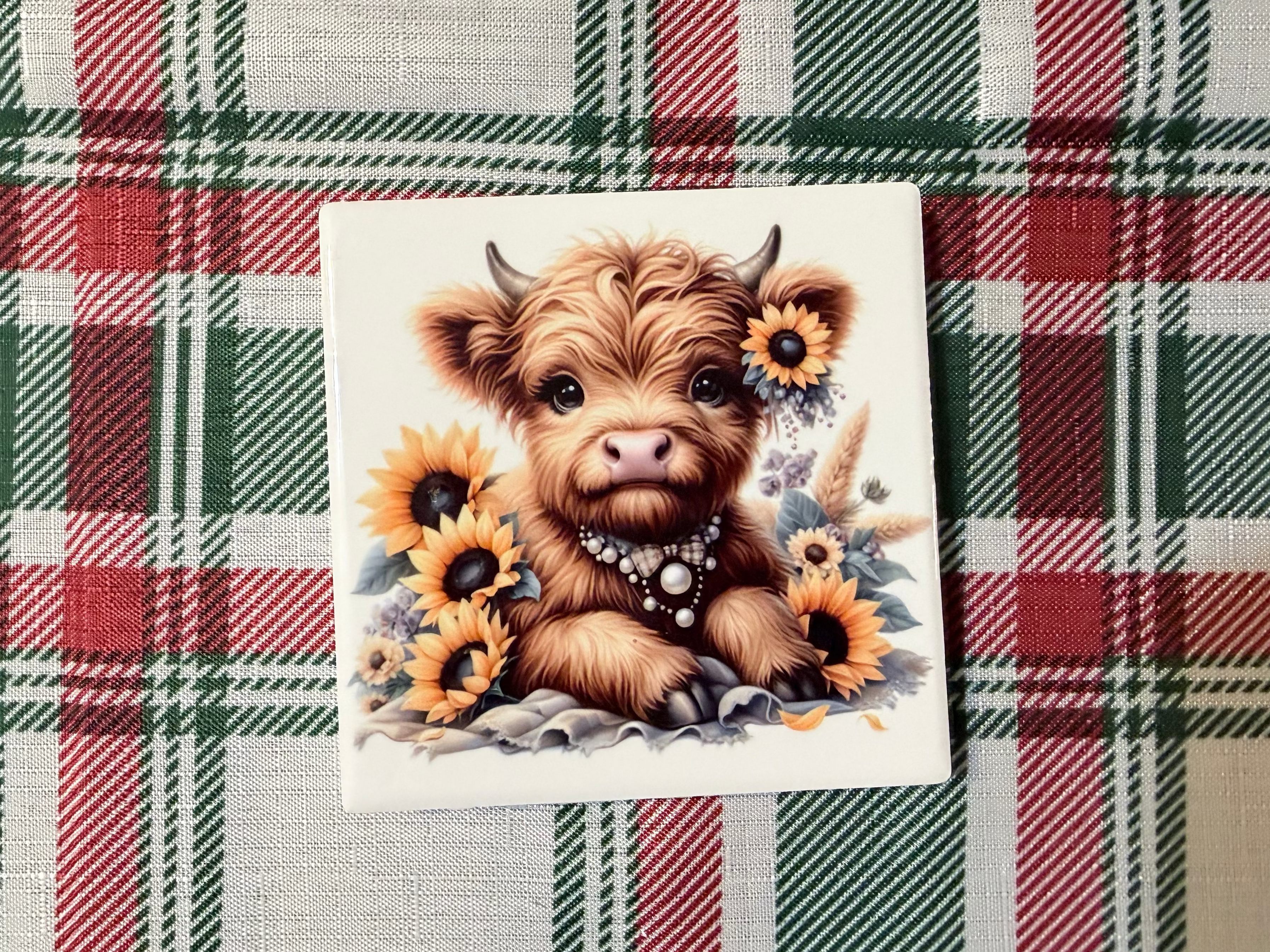 Coaster with a cartoon cow and sunflowers.