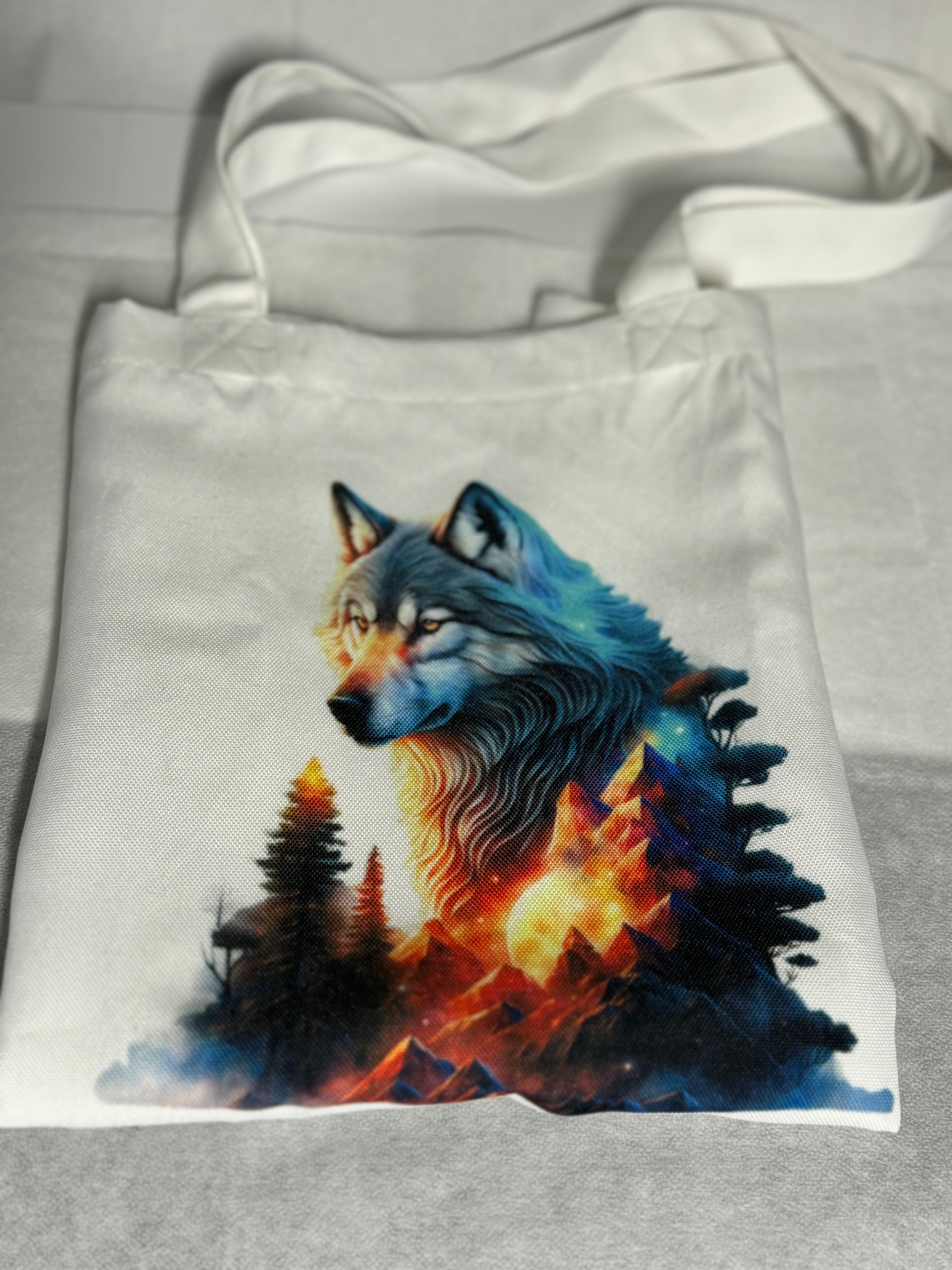 White tote bag with a colorful wolf design.